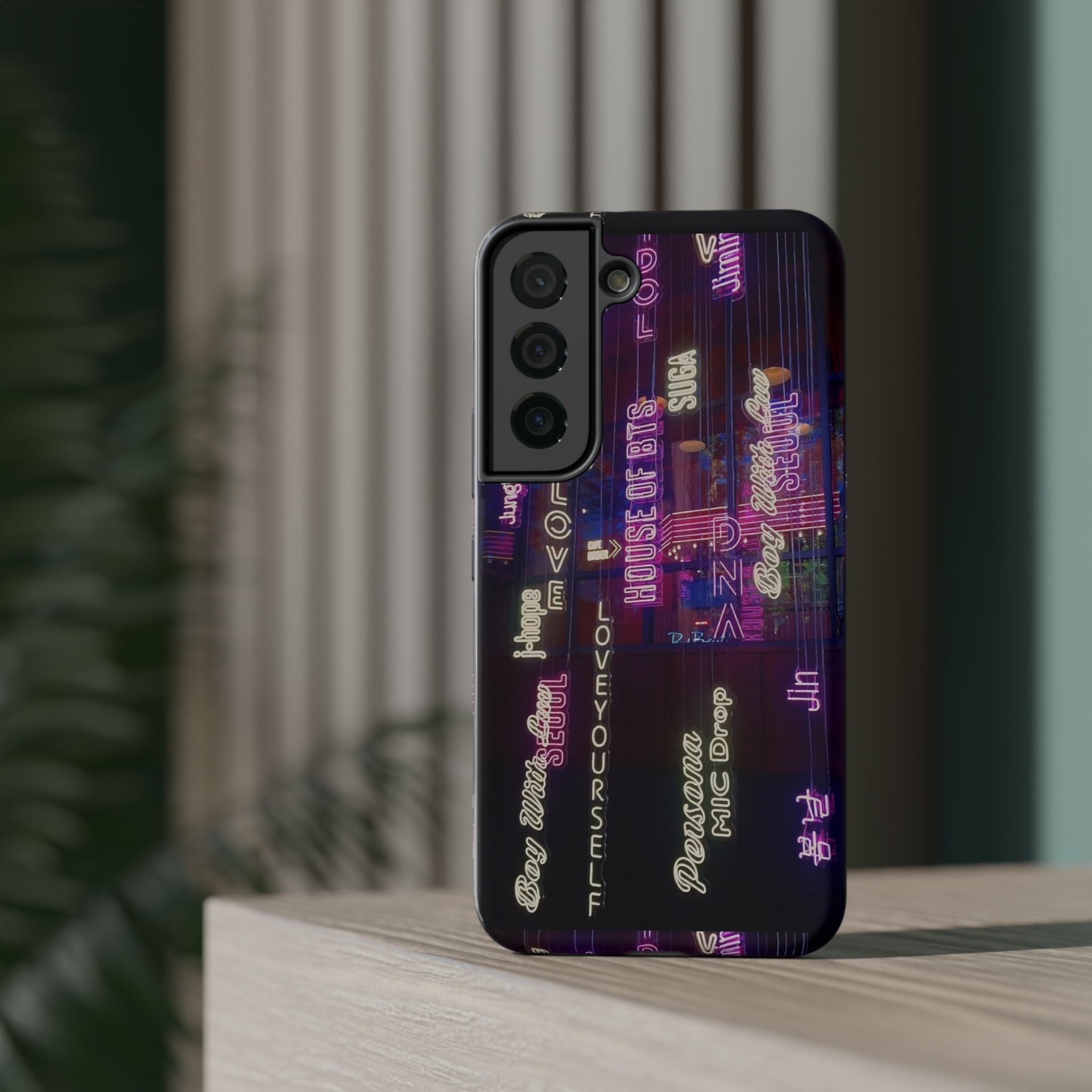Neon Korean script BTS phone case for iPhone and Samsung, impact-resistant design, featuring bold neon lettering and BTS branding.